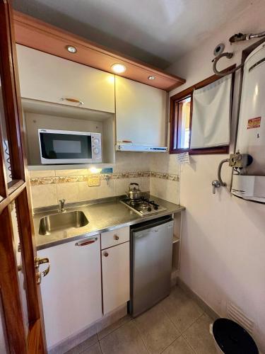 a small kitchen with a sink and a microwave at Rio Apart Hotel in Federación