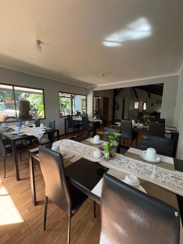 a dining room with tables and chairs and windows at Pumakari Rapa Nui in Hanga Roa