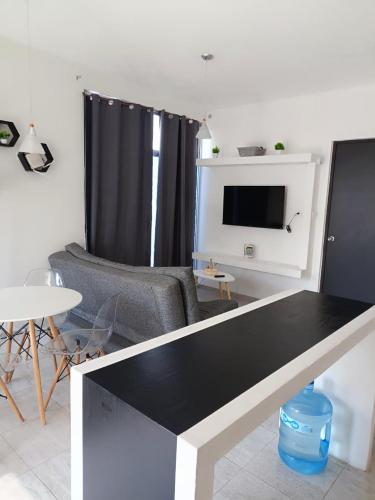 a living room with a table and a tv at Departamento Ejecutivo in Gómez
