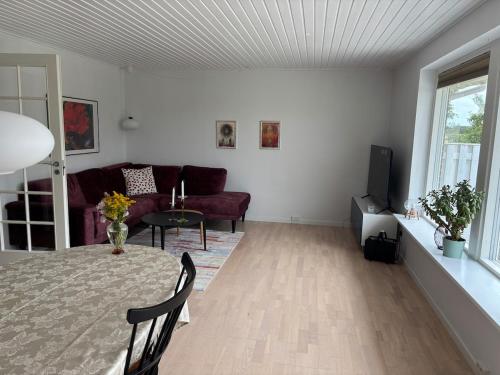 a living room with a couch and a table at Hyggeligt hus i natur område near Aalborg