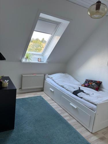 a bedroom with a bed with a window at Hyggeligt hus i natur område near Aalborg