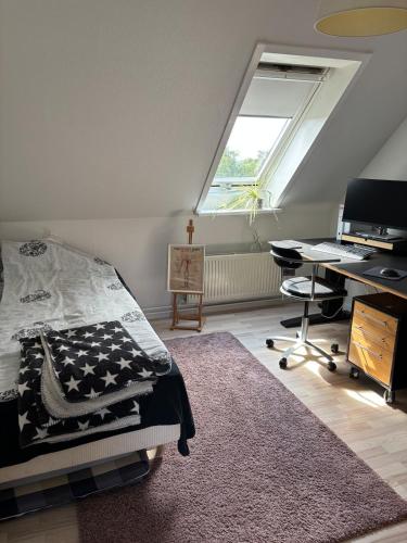 a bedroom with a bed and a desk and a window at Hyggeligt hus i natur område near Aalborg
