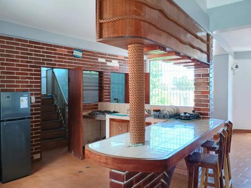 a kitchen with a brick wall and a large kitchen island at Casa Cerdeña in Puerto Carayaca