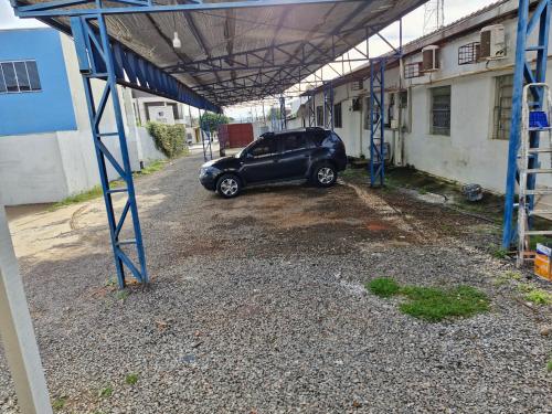 a car parked in a parking lot next to a building at Hotel Bandeirantes de Juina in Juína