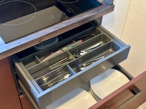 a drawer in a counter with utensils in it at Ferienhaus am Golfplatz in Stromberg