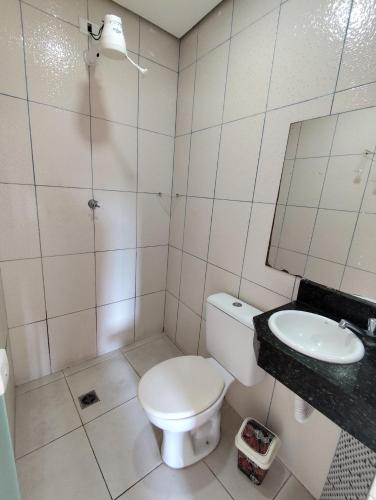 a white bathroom with a toilet and a sink at Hotel Lalique in São Paulo