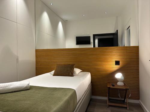 a bedroom with a bed and a wooden headboard at Casa da Calçada in Maceira