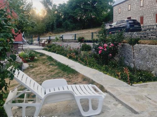 a white bench sitting in a yard next to a building at Seoski dom 