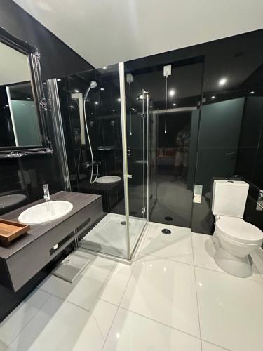 a bathroom with a toilet and a sink and a shower at &Tales Hotel Óbidos in Óbidos
