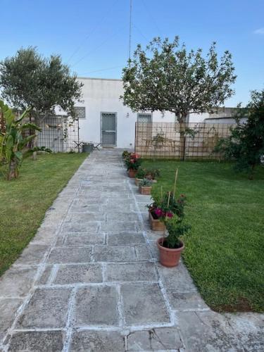 a stone walkway with potted plants in a yard at Casa Vacanze La Vecchia Brace in Lequile