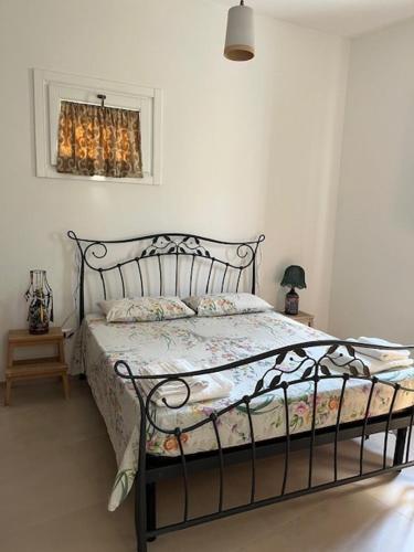a bedroom with a bed with a metal frame at Casa Vacanze La Vecchia Brace in Lequile