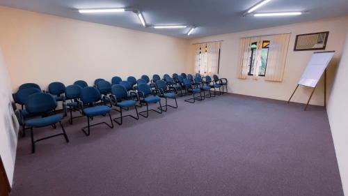 a room with blue chairs and a white wall at Mata Atlântica Park Hotel in Matinhos