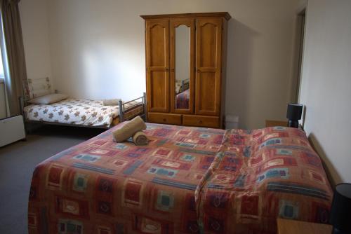 a bedroom with a bed and a dresser in a room at San Michele Adaminaby in Adaminaby