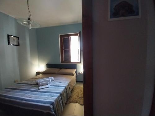a small bedroom with a bed and a window at Borgo nuovo in Donigala Fenughedu