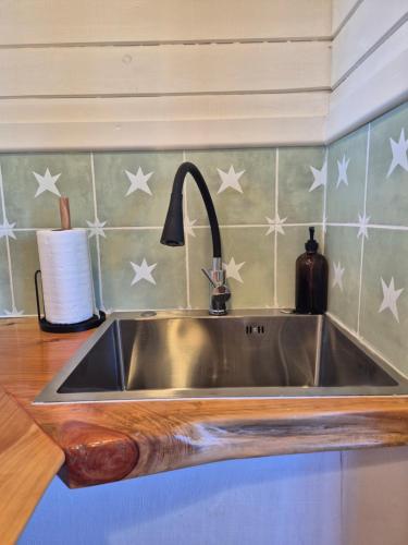 a stainless steel sink in a kitchen with stars on the wall at Casa Coguil - Camino Topocalma in Los Quillayes
