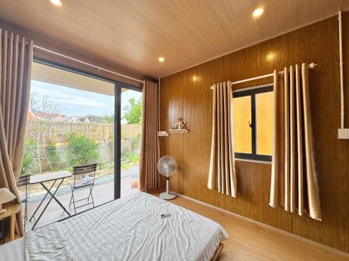 Un dormitorio con una cama y una ventana grande. en Cây Trôm Homestay, en Ninh Hải