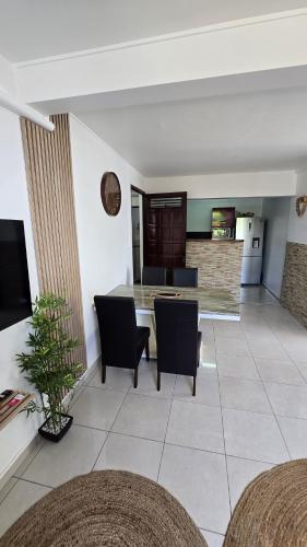a kitchen and living room with a table and chairs at Appartements Des Roses in Le Lamentin
