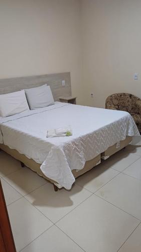 a large bed in a room with a white floor at Casablanca Palace Hotel Frutal MG in Frutal