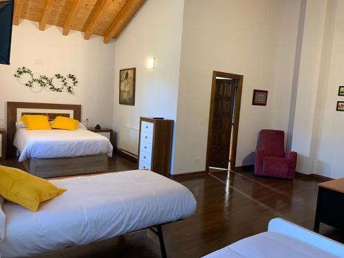 - une chambre avec 2 lits et une chaise dans l'établissement CASA DE LA LASTRA Luena, à San Miguel de Luena