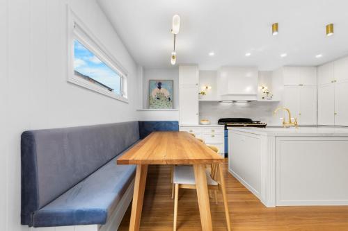 a kitchen with a blue couch and a wooden table at Luxury boutique bay retreat in Williamstown