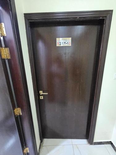 a door with a sign on it in a room at استديو بغرفتين مريحه وجديده in An Naqāʼ