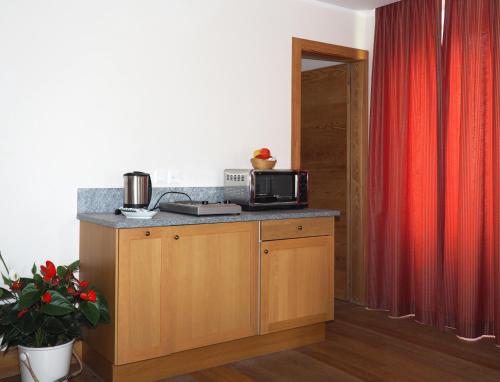 a kitchen with a microwave on top of a counter at Maloja Palace Suites CO2-Neutral in Maloja