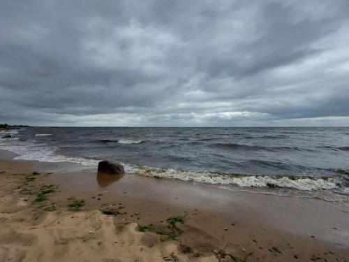 a beach with the ocean on a cloudy day at 6 person holiday home in Hals in Hals