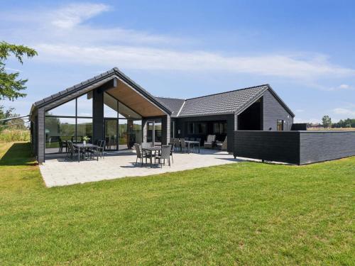 a house with a black roof and a patio at 5 star holiday home in Otterup in Otterup