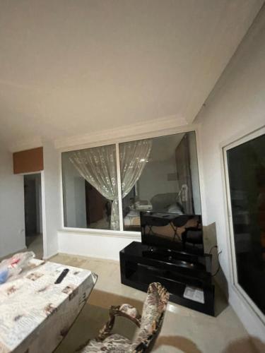 a living room with a large window and a couch at Tunisia hamamet in Manūbah