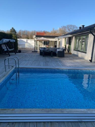 ein Swimmingpool vor einem Haus in der Unterkunft Villa, Heated Pool, Helsingborg in Helsingborg