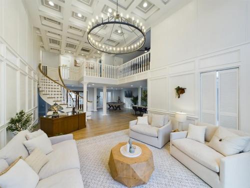 a living room with white furniture and a chandelier at Buckle n Boots BNB - 20 minutes to downtown and pool in Houston