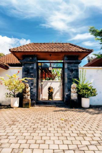 a building with an open door with potted plants at Tattva Ubud Retreat & Wellness in Ubud