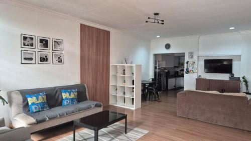 uma sala de estar com um sofá e uma mesa em Dago Family Stay em Bandung