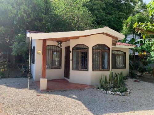una pequeña casa con una puerta en un patio en Oceana Breeze Perfect Getaway steps from the beach, en Sámara
