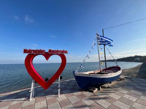 a red heart on a sign next to a boat at Makrygialos-Atlantis in Makrýgialos