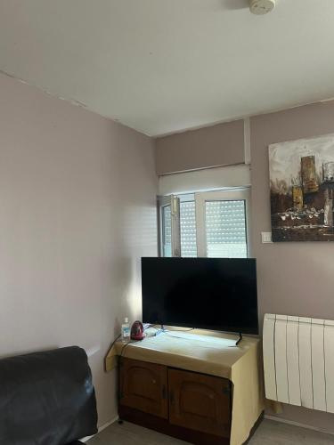 a living room with a flat screen tv on a wall at Appartement calme, frais à louer, nouvellement repeint, emplacement stratégique, proche de toutes commodités, de l'autoroute, valenciennes, lille, Belgique, wifi, Netflix, parking Gratuits in Raismes