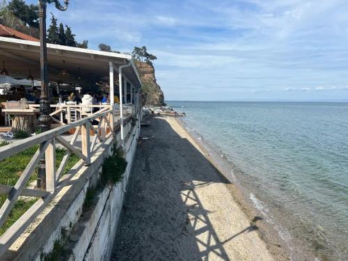 a building next to the ocean with people standing on a beach at Makrygialos-Atlantis in Makrýgialos