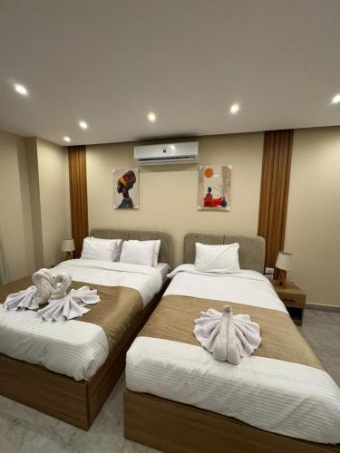 deux lits dans une chambre d'hôtel avec des serviettes dessus dans l'établissement pyramids palace view, au Caire