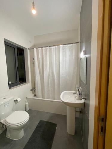 Un baño blanco con inodoro y lavabo. en Family Flat in San Gwann, en San Ġwann
