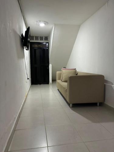 a living room with a couch and a black door at Amplia y cómoda casa en Bello in Bello