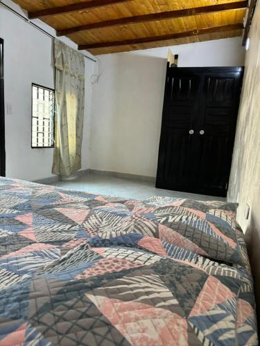 a bedroom with a bed with a colorful quilt at Amplia y cómoda casa en Bello in Bello