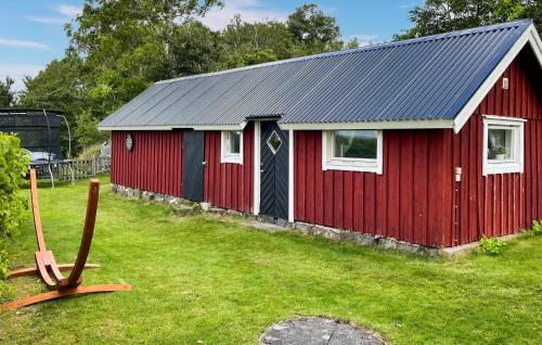 a red barn with a metal roof on a yard at Nice Home In Vinberg With House A Panoramic View in Vinberg