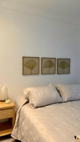 tre dipinti su una parete sopra un letto con un tavolo di Capibara 4 - Imponente vista al Río a Corrientes