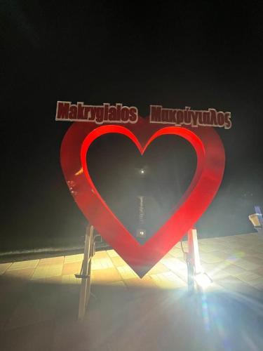 a large red heart sign with the words maligning humans at Makrygialos-Atlantis in Makrýgialos