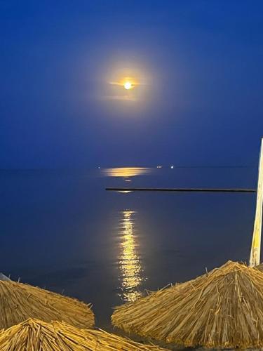a full moon rising over the water at night at Makrygialos-Atlantis in Makrýgialos