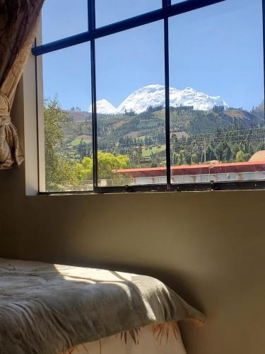 a bedroom with a window with a view of a mountain at Acowasi in Acopampa
