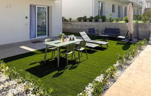 a patio with a table and chairs on grass at Stunning Apartment In Marzamemi in Marzamemi