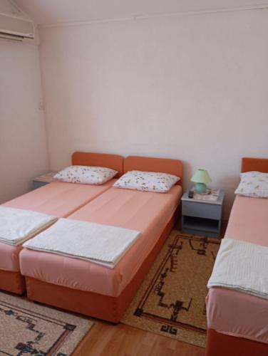 a bedroom with two beds and a rug at Guesthouse Villa Sara in Mostar