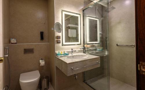 a bathroom with a toilet and a sink and a shower at Sunset Jeddah in Jeddah