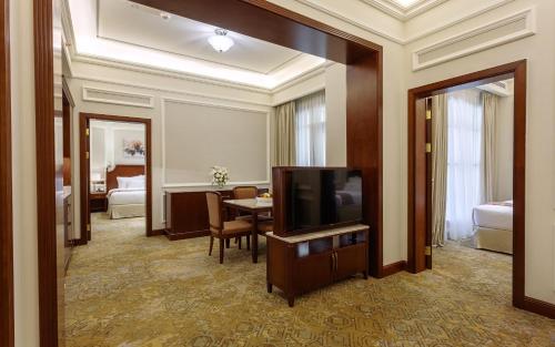 a hotel room with a television and a dining room at Sunset Jeddah in Jeddah